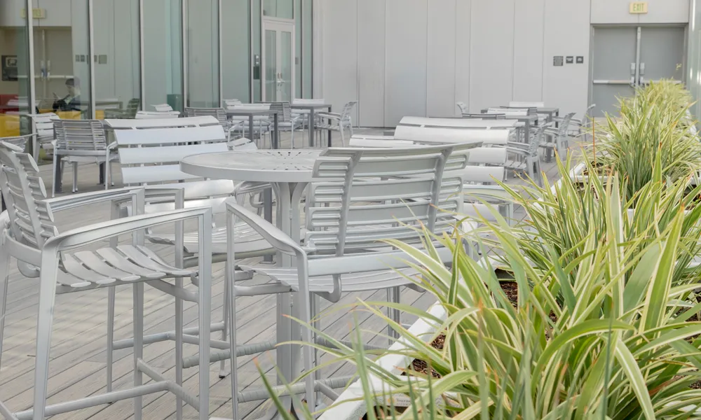 A spacious outdoor terrace with modern seating, surrounded by mountain views and natural lighting.