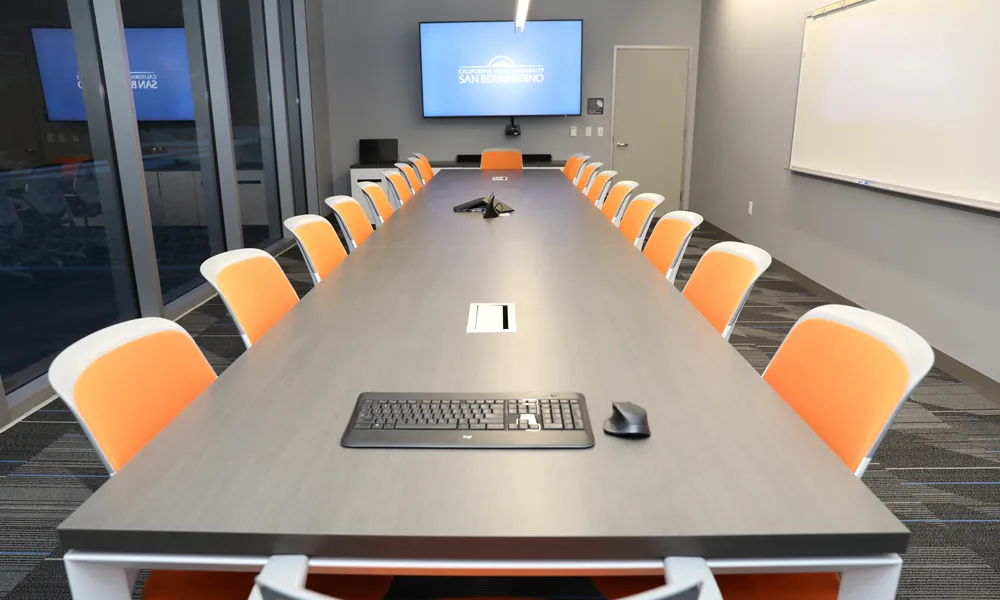 A sleek, tech-enabled meeting space with touch-screen controls, a video conferencing system, and modern lighting.