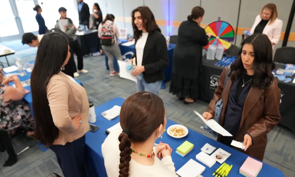 Students attending the April 2024 Career Fair at a booth talking to employers
