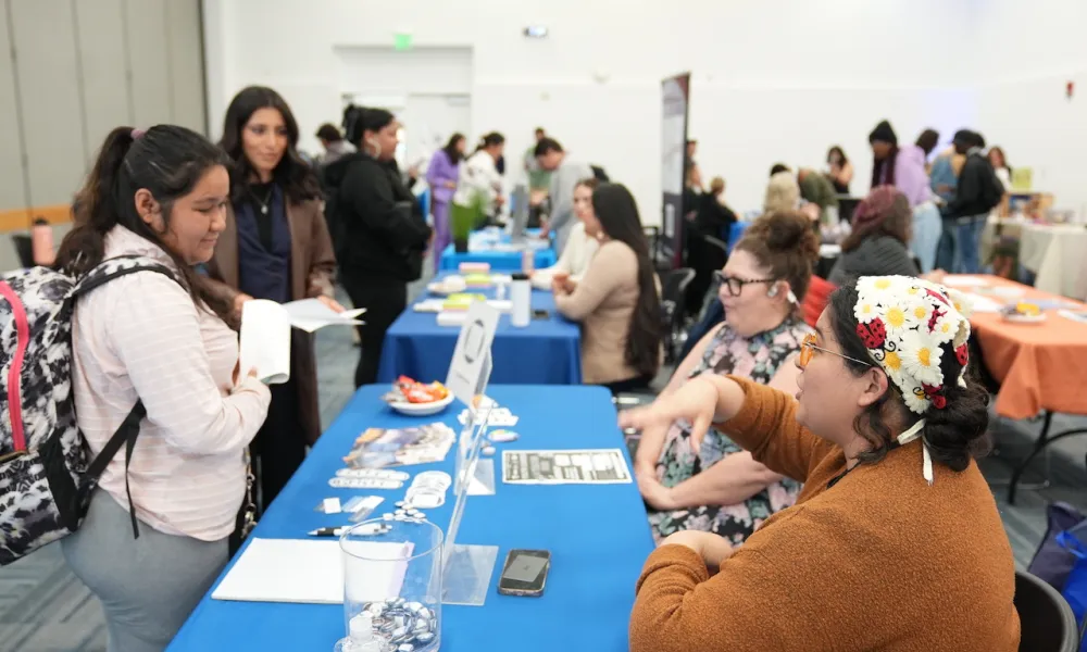 Students attending the April 2024 Career Fair at a booth talking to employers