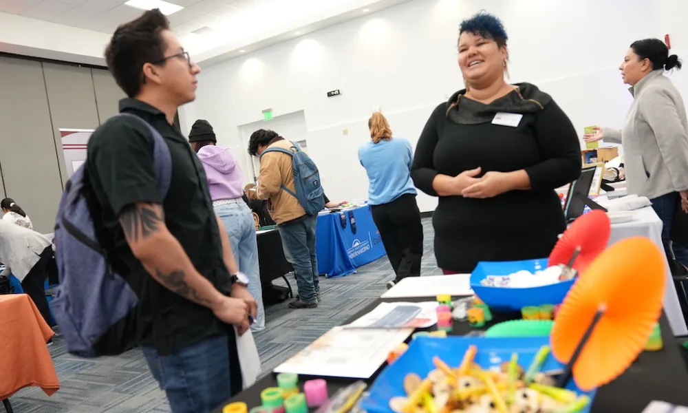 Students attending the April 2024 Career Fair at a booth talking to employers
