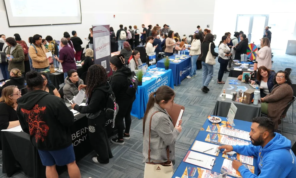 Students attending the April 2024 Career Fair at a booth talking to employers
