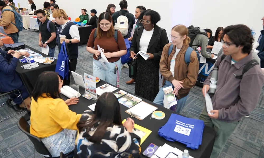 Students attending the April 2024 Career Fair at a booth talking to employers