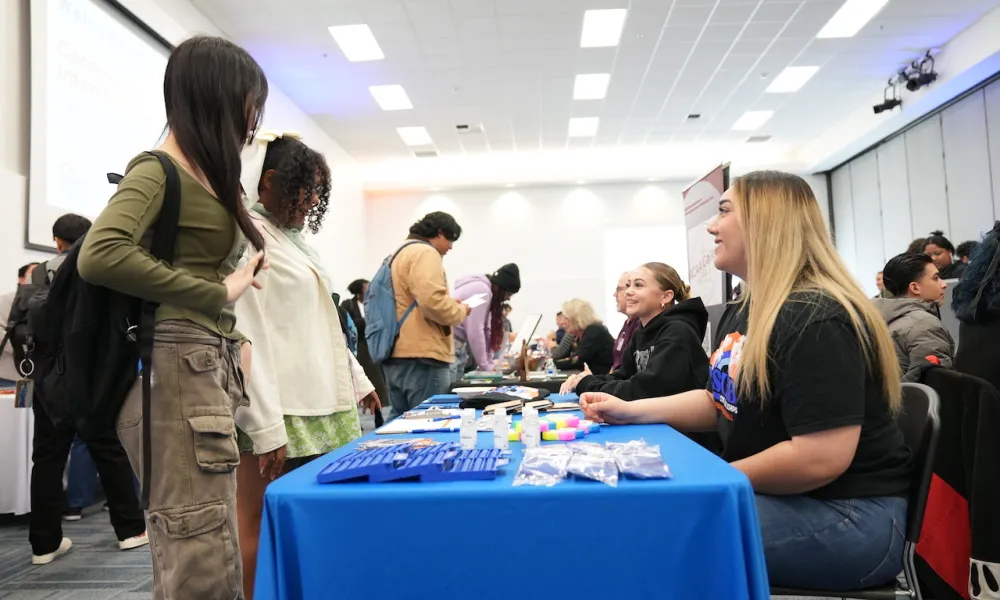 Students attending the April 2024 Career Fair at a booth talking to employers