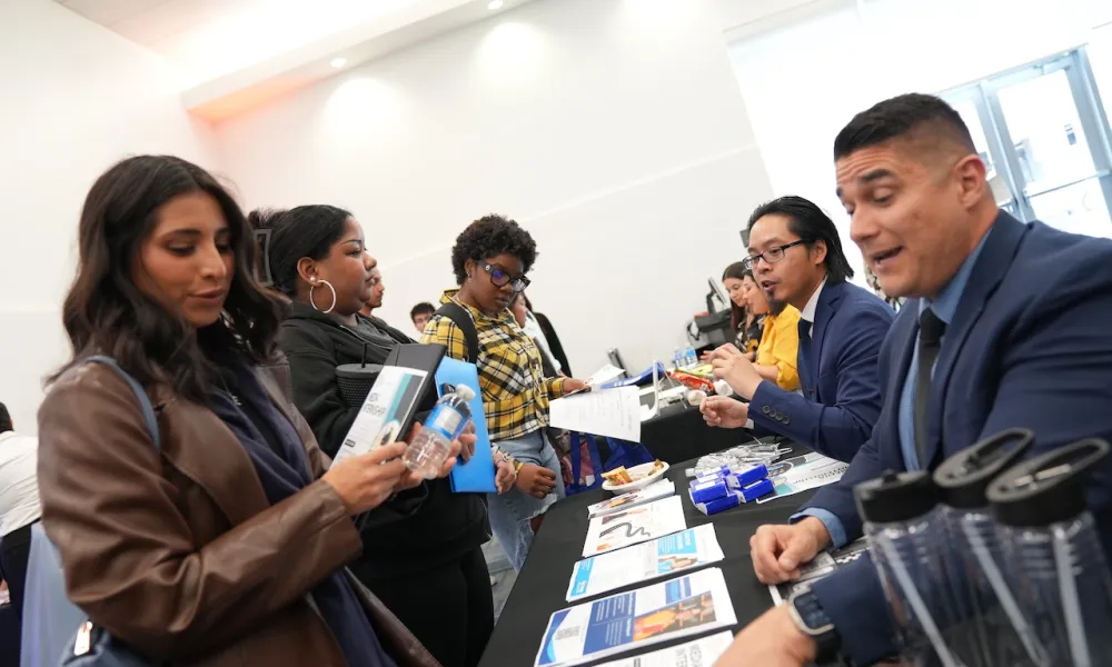 Students attending the April 2024 Career Fair at a booth talking to employers