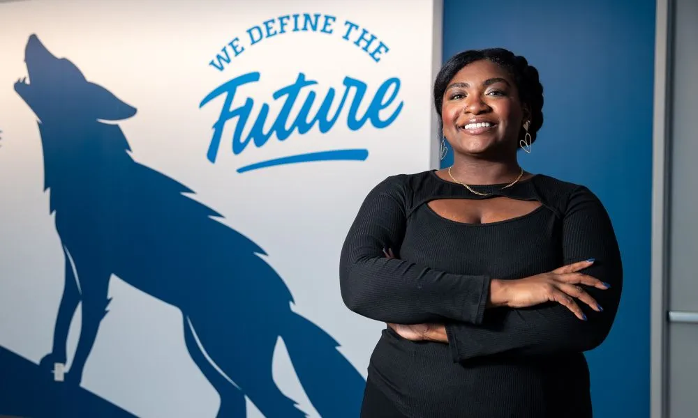 Marlena Brown stands by We Define the Future sign