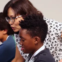 image of teacher helping students with computer