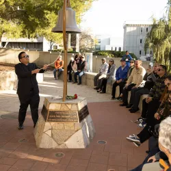 Michael Nguyen, a former faculty member in the Department of Health Science and Human Ecology, rings the bell at Cal State San Bernardino’s Peace Garden during the 2023 Day of Remembrance. 