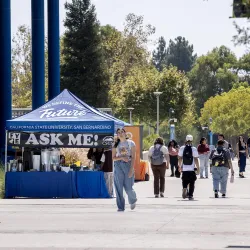Students on Coyote Walk pass an "Ask Me!" table on Aug. 26, the first day of the 2024 fall semester.