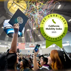 Student celebrating graduation at the CSUSB spirit letters with the College Futures Foundation California Mobility Index graphics badge.