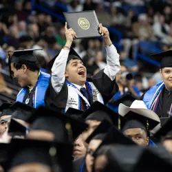 A member of CSUSB’s Class of 2025 celebrates during one of the five commencement ceremonies that took place in May