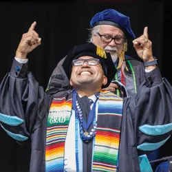 Juan Carlos Luna (front), is awarded his doctorate degree from Enrique Murillo Jr. director of Doctorate in Educational Leadership program in the James R. Watson & Judy Rodriguez Watson College of Education, during the May 2025 Commencement exercises.