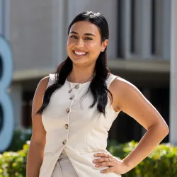 Angela Padilla Vidarte standing in front of CSUSB letters