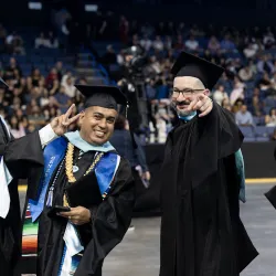 Two members of CSUSB’s Class of 2026 celebrate at the ceremony for the College of Arts and Letters and the James R. Watson and Judy Rodriguez Watson College of Education at Toyota Arena on May 16.