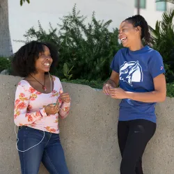 Two African American women laughing on the CSUSB campus.