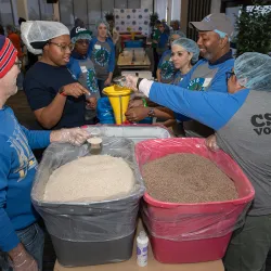 CSUSB alumni and staff Coyote Cares Day volunteers prepare ingredients for jambalaya soup mix. 