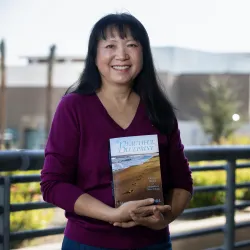 CSUSB professor Mary Fong holding her memoir