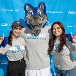 Two students and Cody Coyote in Giving Tuesday T-shirts