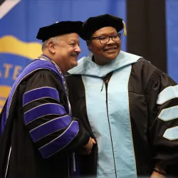 Cherina Betters (right) is congratulated by CSUSB President Tomás D. Morales upon receiving her Ed.D. degree.