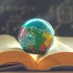 Model globe sitting on an open book.