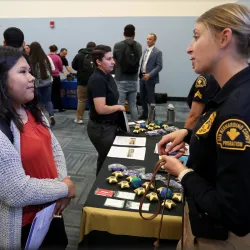 A student and a law enforcement officer meet at the 2020 criminal justice career fair.