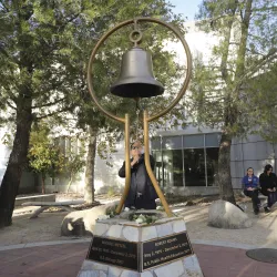 Michael Nguyen rings the bell during the 2019 Day of Remembrance at the university’s Peace Garden