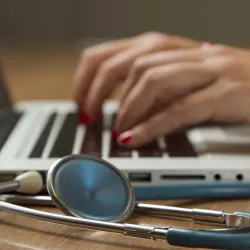 Hands typing on laptop