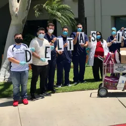 CSUSB Delta Sigma Phi Eta Beta chapter members stand alongside hospital staff at Dignity Health Community Hospital in San Bernardino. The chapter had raised more than $1,000 and bought meals for the hospital staff. 