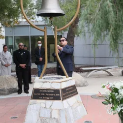 Michael Nguyen, a former faculty member in the Department of Health Science and Human Ecology, rings the bell at the Peace Garden on the Day of Remembrance, Dec. 2.
