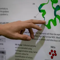 A hand pointing at a research poster