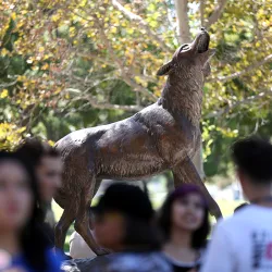 Students surrounding CSUSB’s Wild Song statue 