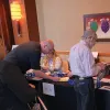 Staff greet guests as they enter the CAE in Cybersecurity Symposium. Photo by: Staff