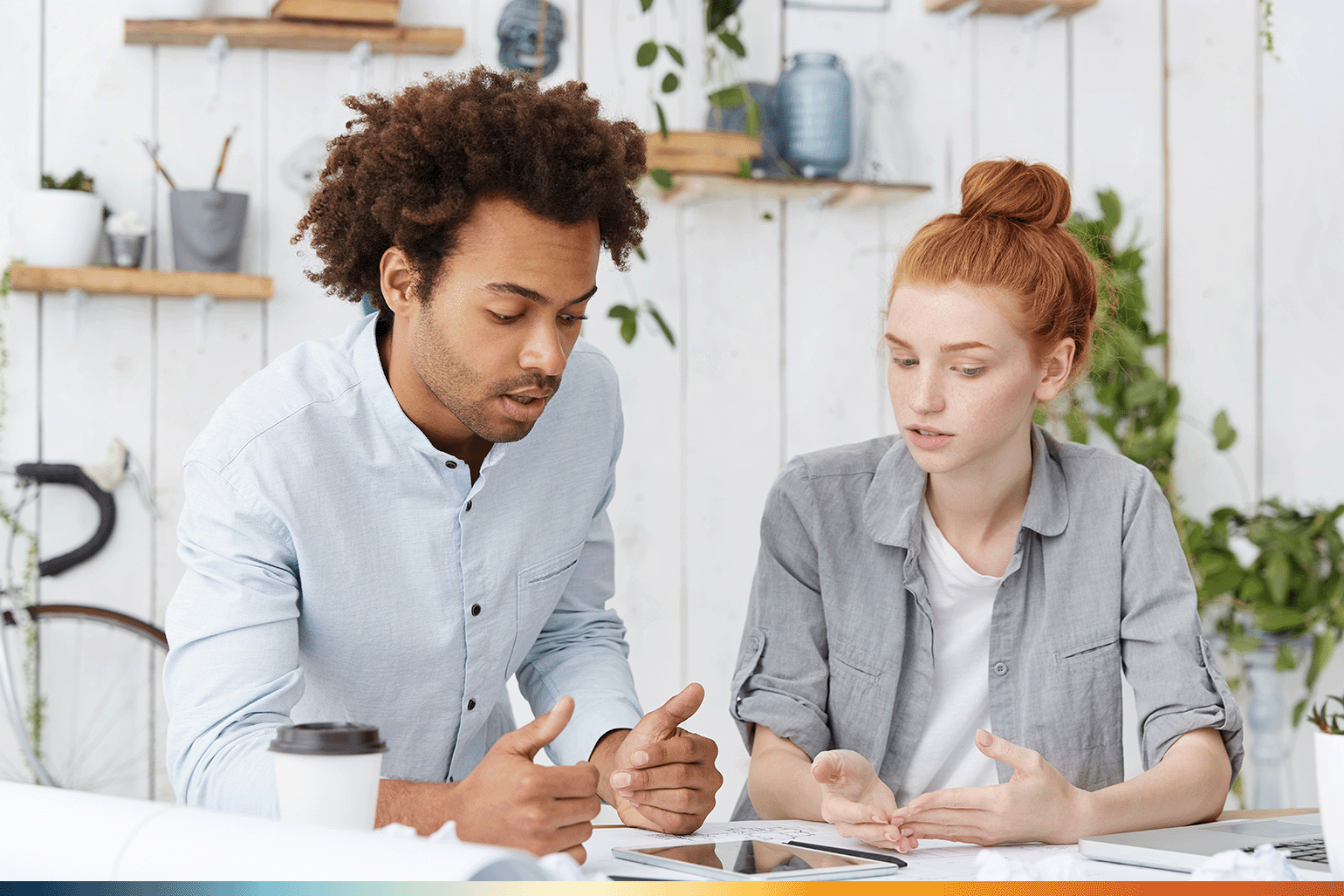 The image shows to people working together on a laptop