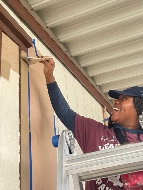 CSUSB student painting a mobile home for the Brush of Kindness.