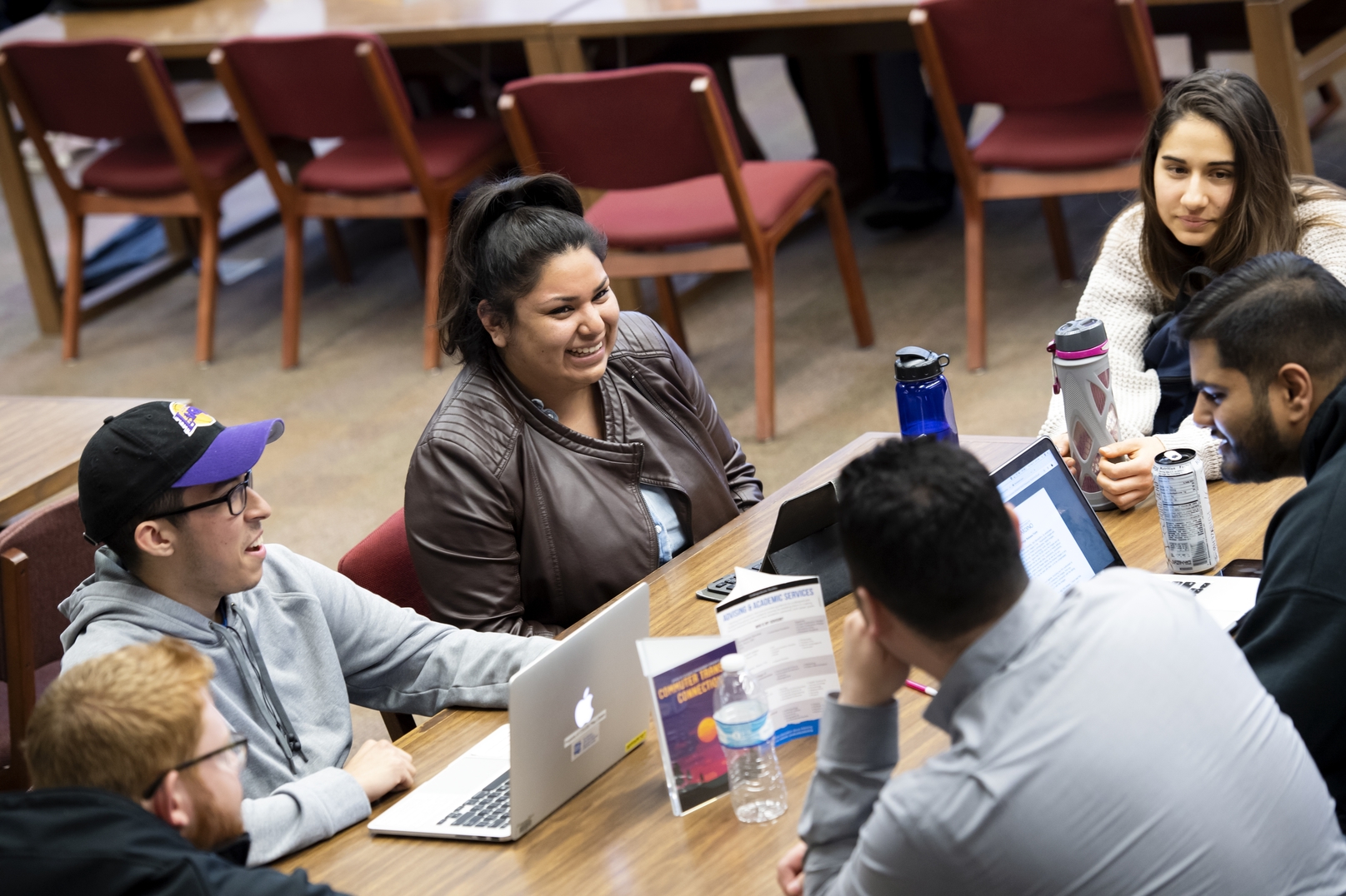 Students talking and laughing at a table.