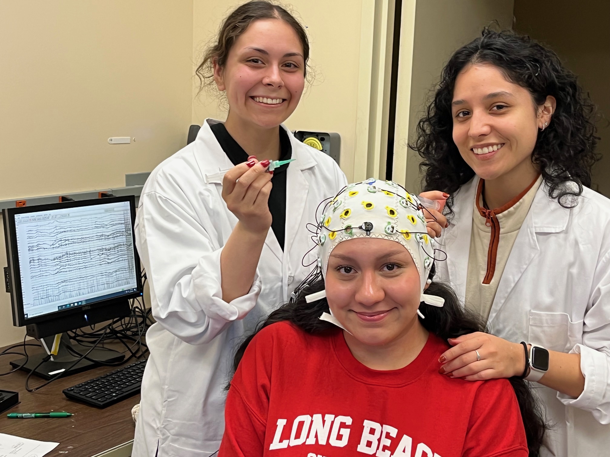 Honor student Camryn Amundsen and Master’s student Melissa Lopez prepare a participant for EEG data acquisition.