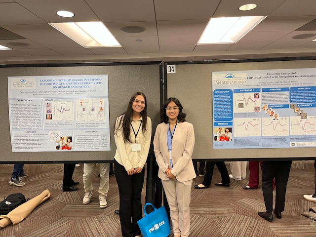 Honor student Camryn Amundsen and URISE student Britney Aguire proudly pose next to their respective posters.