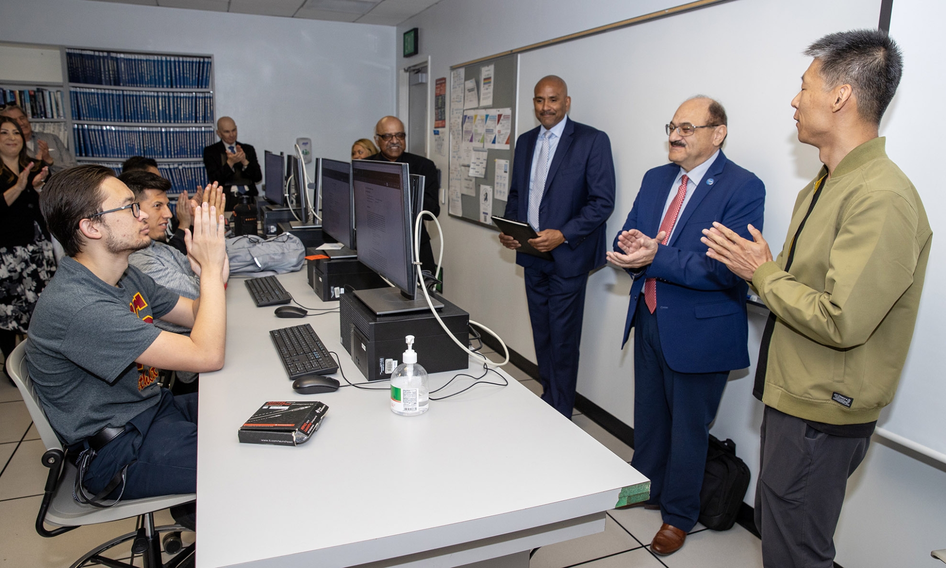 From left, partially hidden by a computer monitor, is Sastry Pantula, dean of the College of Natural Sciences; Rafik Mohamed, provost and vice president of Academic Affairs; Khalil Dajani, director of the School of Computer Science and Engineering; and Qingquan Sun, recipient of the university’s 2023-24 Outstanding Scholarship, Research and Creative Activities Award.