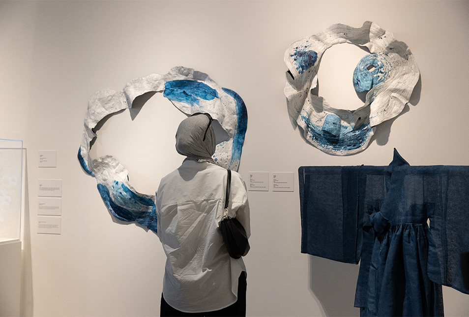 Woman standing viewing mounted art pieces in museum