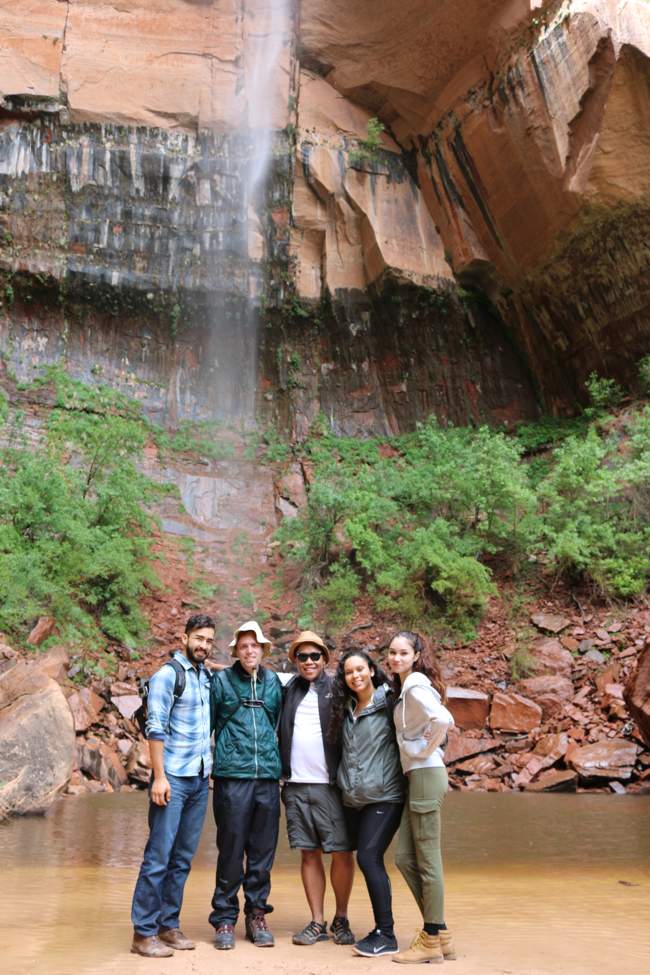 4 people standing in front of waterfall