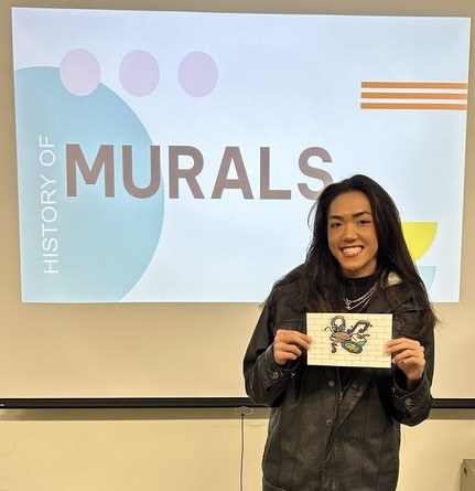 Student showing their miniature mural