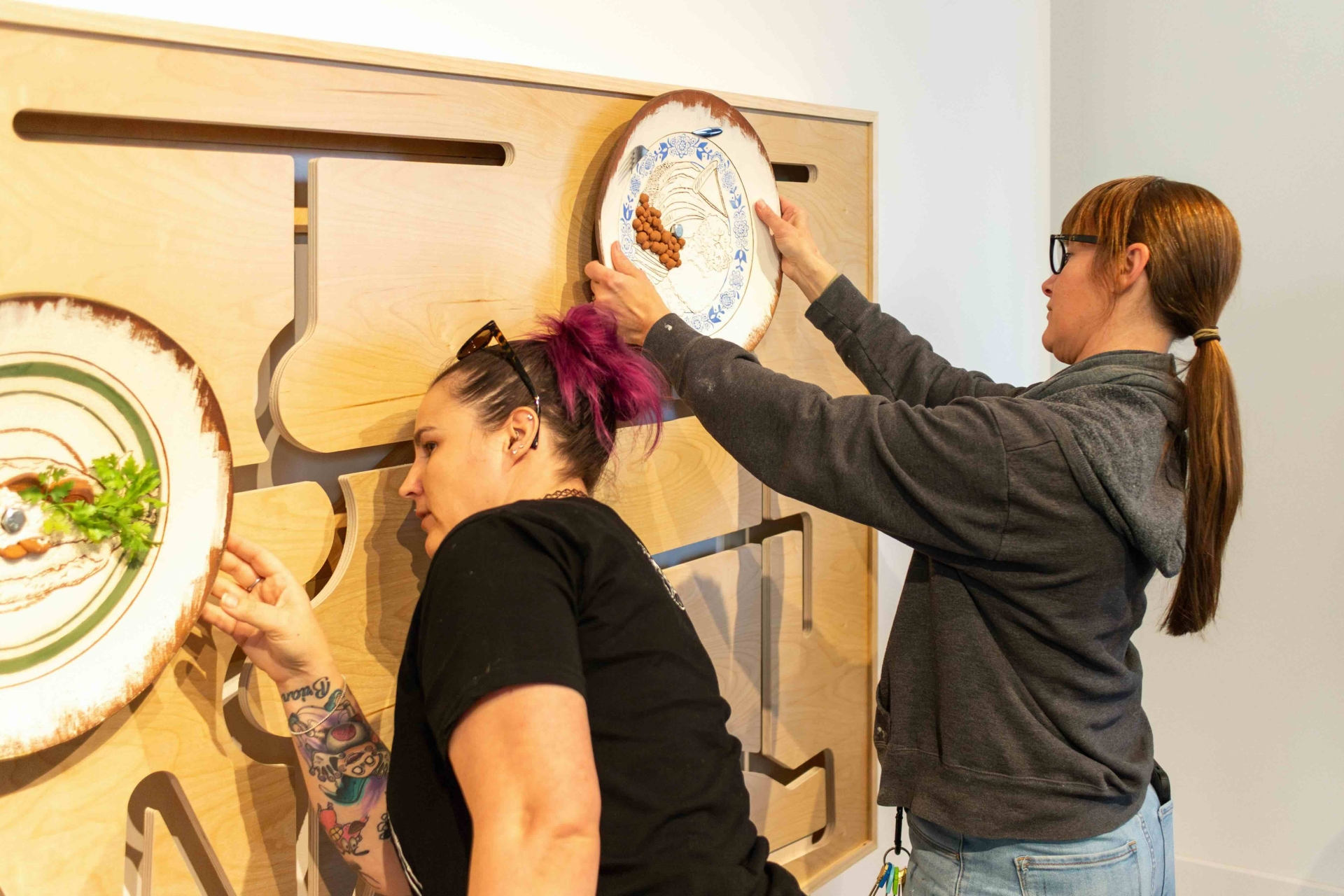 two individuals interacting with a piece from Salvadoran Roots, American Dreams exhibition