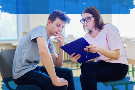 3. A woman and a boy are sitting in a classroom, participating in a discussion.