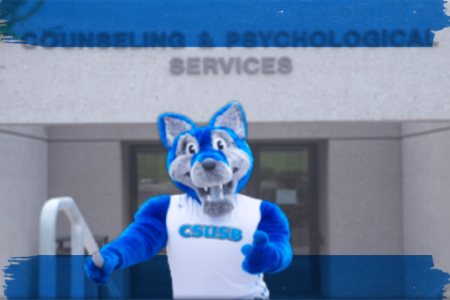  A blue coyote mascot poses in front of a building, representing school pride and community engagement.