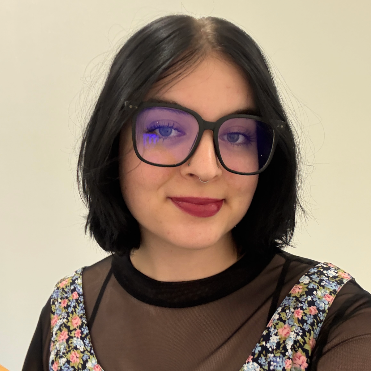 Photo of Alicia Juarez wearing glasses and a dress