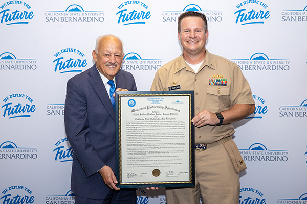 CSUSB President Tomás D. Morales and Navy Capt. Joseph Burgon with the signed Education Partnership Agreement.