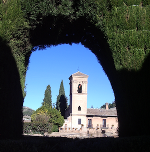 View of castle in Spain as seen through a hole in a hedge