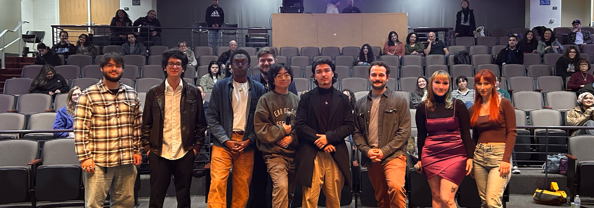 From left to right, Ryan Martinez, Abraham Figueroa Flores, Johnny Mikoyan, Ryan Kanamoto, Richard Arellano, Marco Antonio Rimicci, Mikayla Ellwood, and Mariana Duran are pictured standing on stage