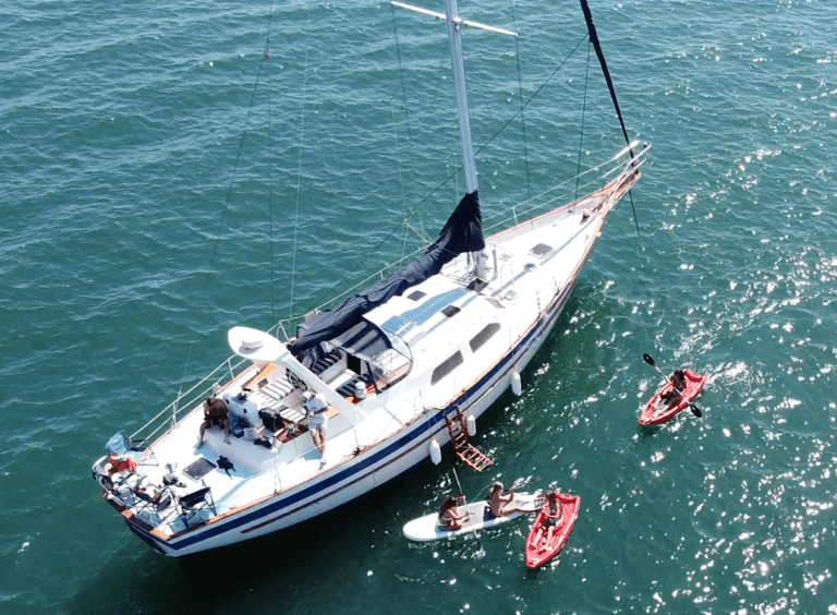 55 foot sail boat in ocean with kayak near it