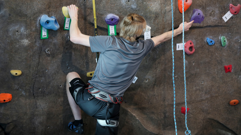 student rock climbing